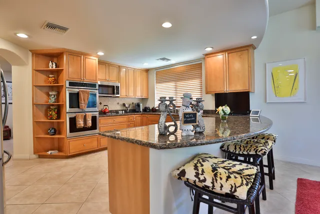 a living room with furniture kitchen view and a large window