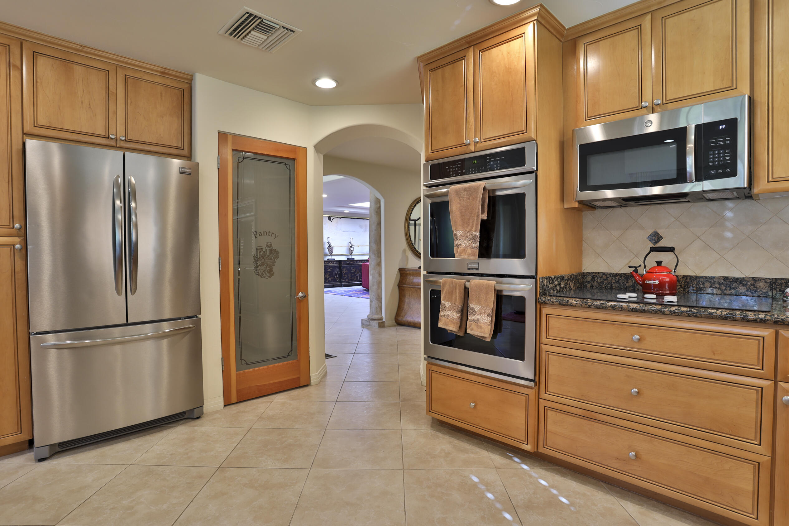 45735 Pawnee Road Indian Wells, CA 92210 - Photo 23 of 74 a kitchen with stainless steel appliances granite countertop a refrigerator and microwave