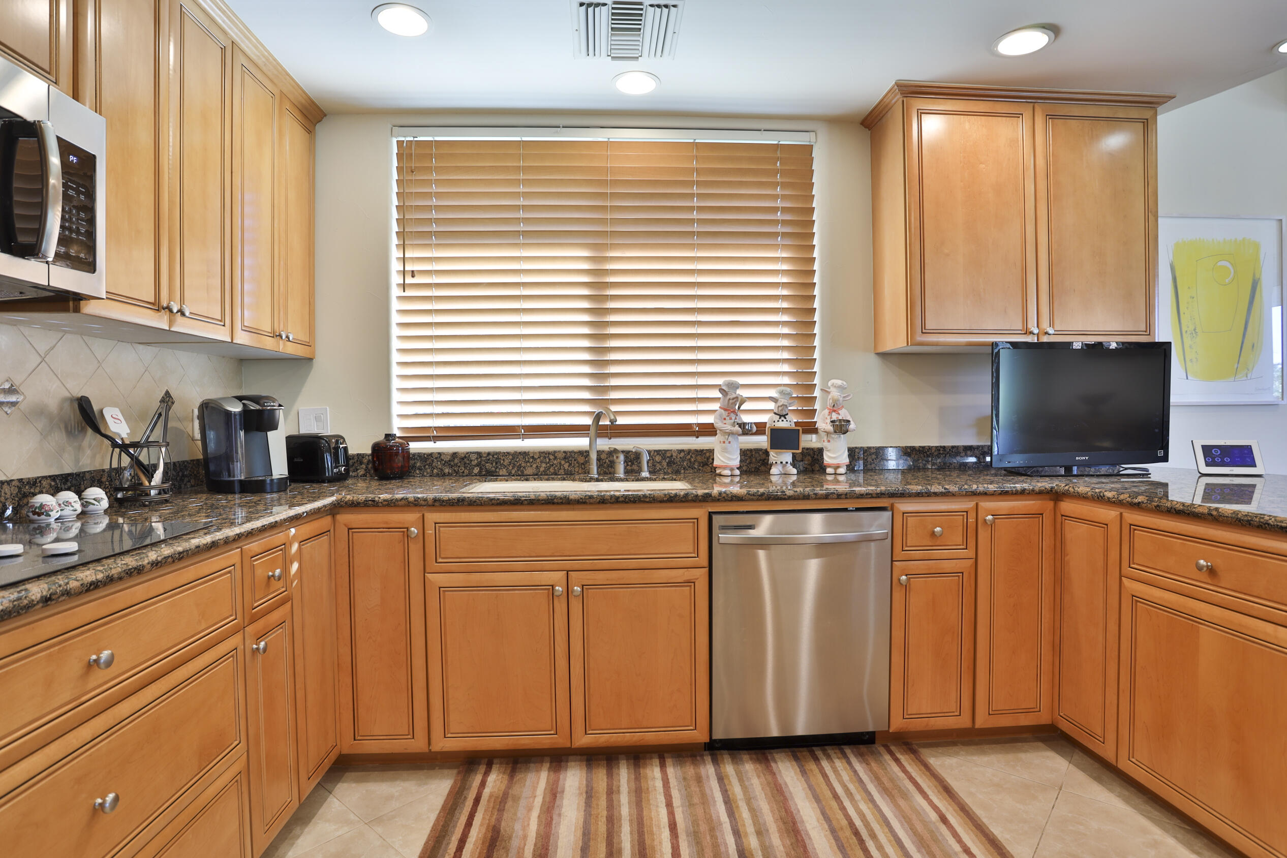 45735 Pawnee Road Indian Wells, CA 92210 - Photo 25 of 74 a kitchen with stainless steel appliances granite countertop white cabinets sink and a large window