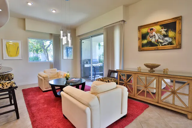 a living room with stainless steel appliances furniture and a large window