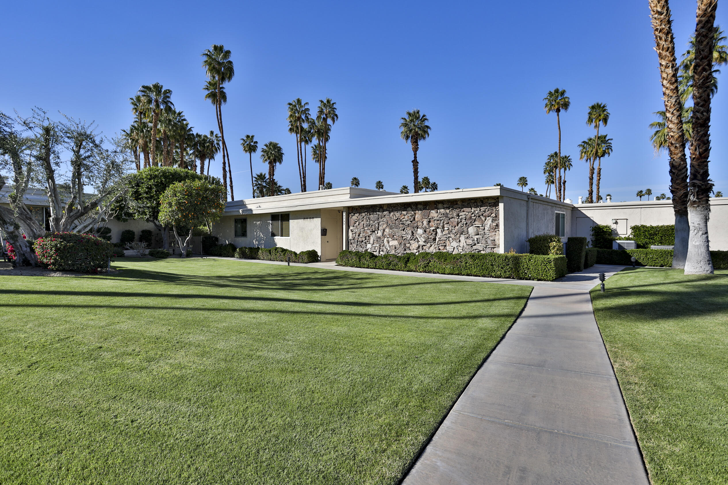 45735 Pawnee Road Indian Wells, CA 92210 - Photo 9 of 74 a front view of a house with a yard and potted plants