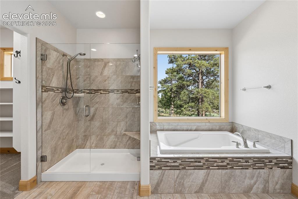 10840 Vollmer Road Colorado Springs, CO 80908 - Photo 27 of 49 a bathroom with a granite countertop shower bathtub and window