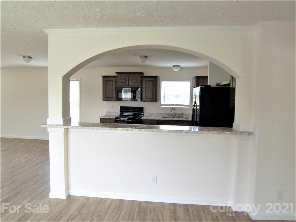 3808 Fallston Road Shelby, NC 28150 - Photo 4 of 18 a living room with stainless steel appliances kitchen island granite countertop a refrigerator a stove and a microwave