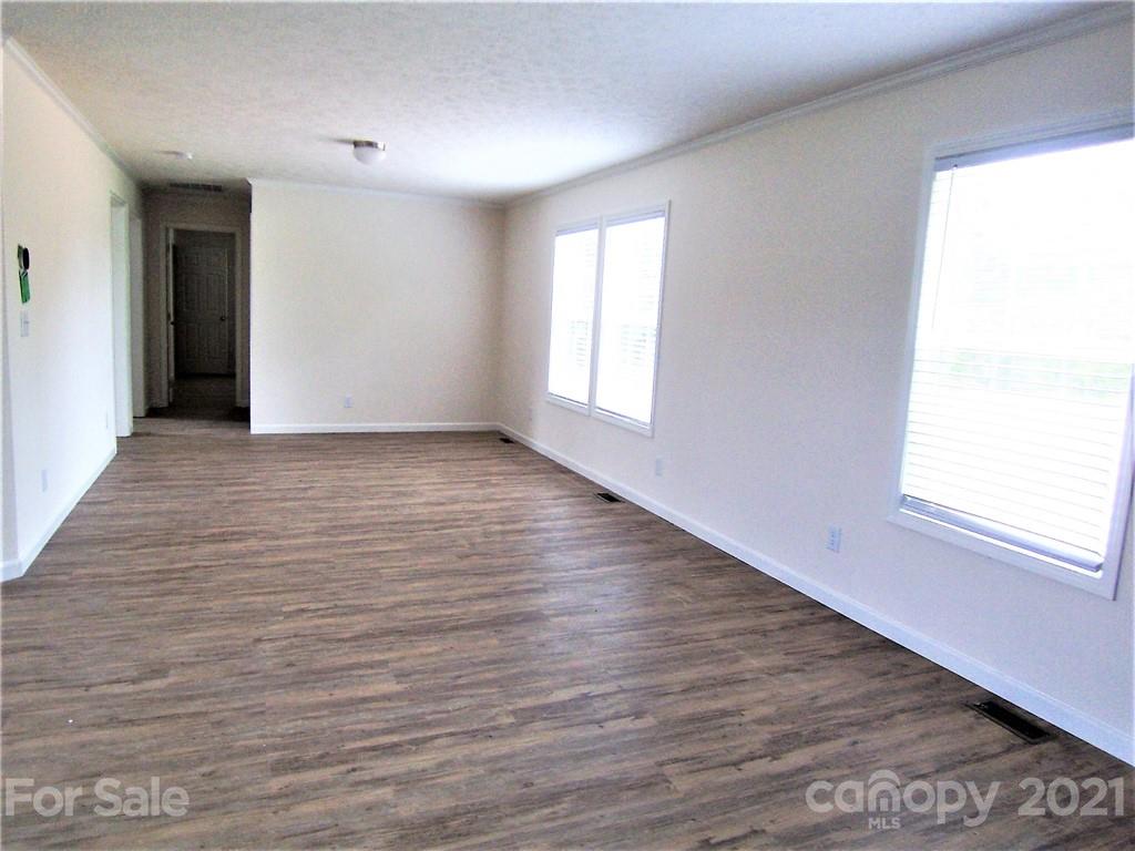 3808 Fallston Road Shelby, NC 28150 - Photo 5 of 18 a view of an empty room with wooden floor and a window