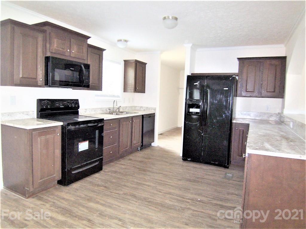 3808 Fallston Road Shelby, NC 28150 - Photo 6 of 18 a kitchen with stainless steel appliances granite countertop a refrigerator a stove a sink and a microwave