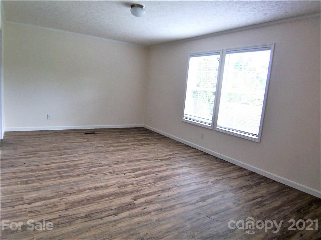 3808 Fallston Road Shelby, NC 28150 - Photo 10 of 18 an empty room with wooden floor and windows