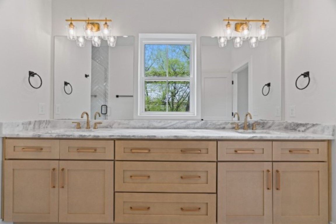 603 Morrow Road, Unit A Nashville, TN 37209 - Photo 27 of 38 a bathroom with white cabinets and a chandelier