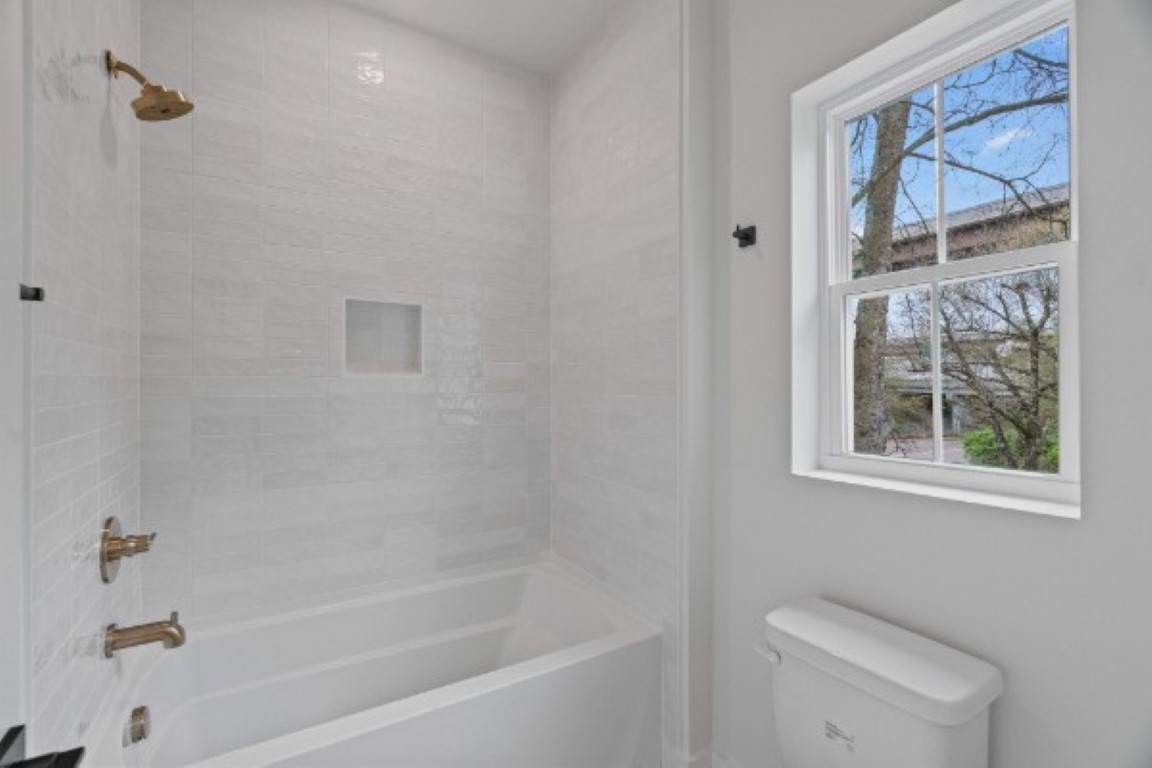 603 Morrow Road, Unit A Nashville, TN 37209 - Photo 30 of 38 a bath room with a toilet a bath tub and a window
