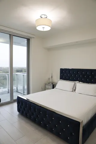 a spacious bedroom with a bed and a night stand