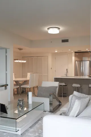 a living room with furniture and kitchen view