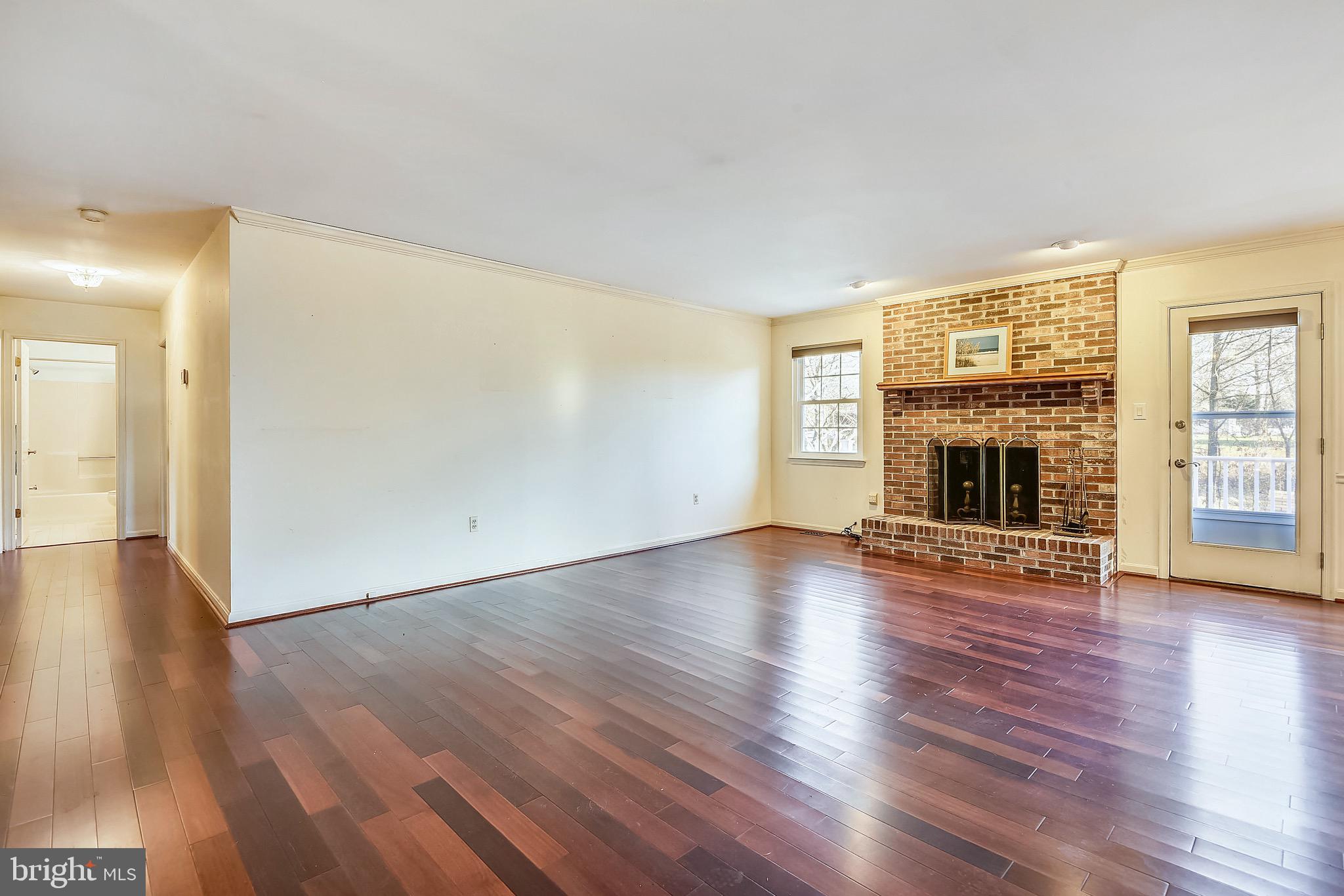 2515 Potts Point Road Huntingtown, MD 20639 - Photo 8 of 19 an empty room with wooden floor fireplace and windows