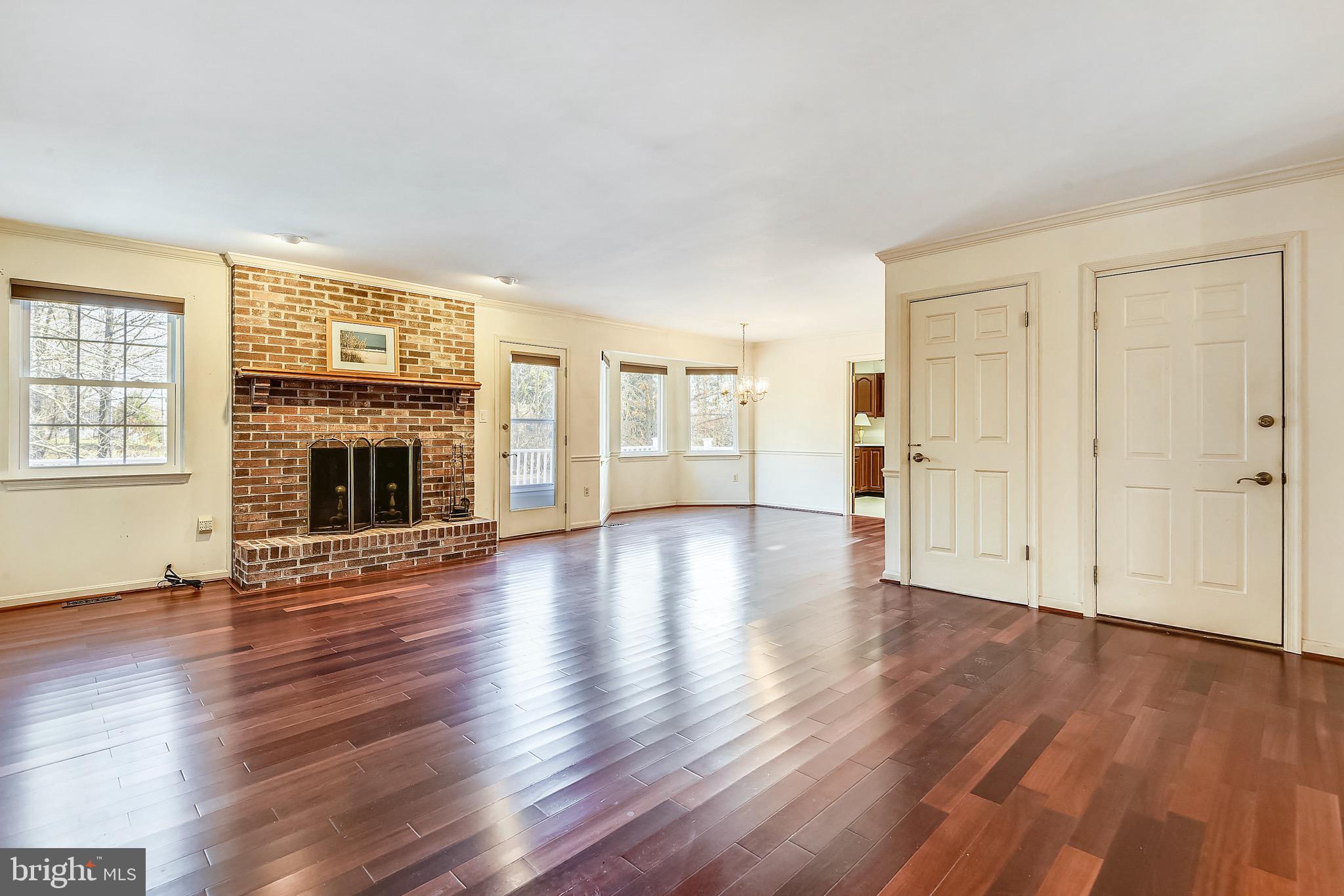 2515 Potts Point Road Huntingtown, MD 20639 - Photo 9 of 19 an empty room with wooden floor fireplace and windows