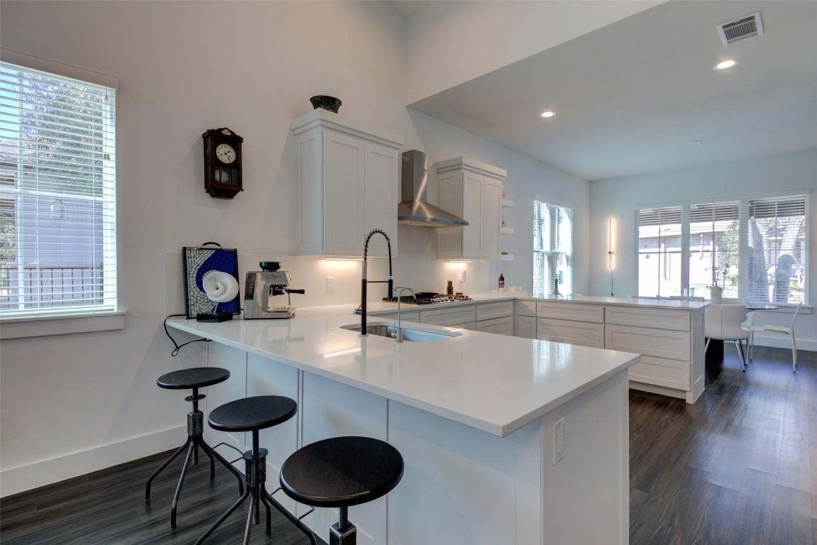 170 Bunker Rnch Boulevard, Unit 64 Dripping Springs, TX 78620 - Photo 15 of 37 a kitchen with stainless steel appliances granite countertop a sink a stove and a wooden floors