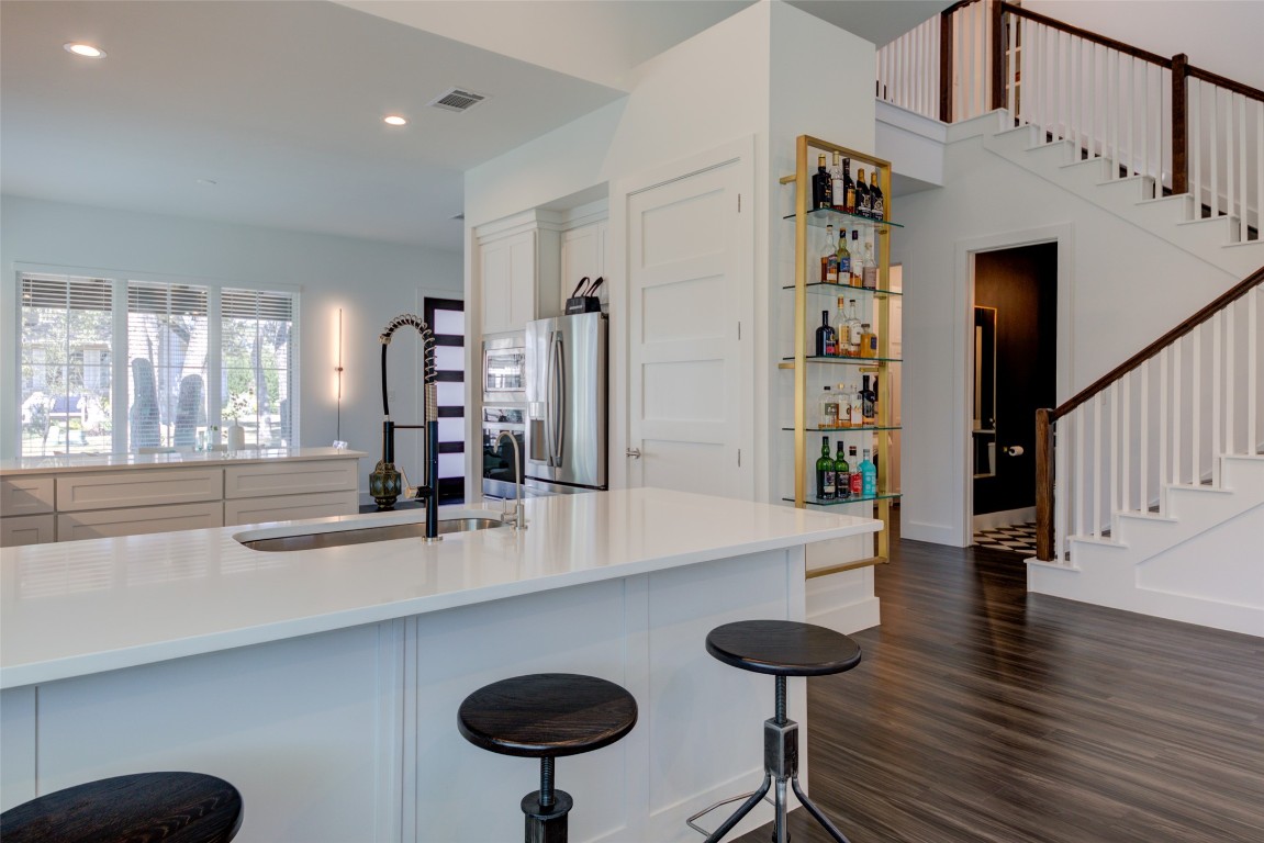 170 Bunker Rnch Boulevard, Unit 64 Dripping Springs, TX 78620 - Photo 16 of 37 a room with stainless steel appliances kitchen island a table chairs in it and living room