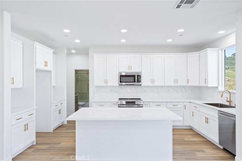 1981 Lyon Avenue Riverside, CA 92503 - Photo 14 of 58 a kitchen with stainless steel appliances a refrigerator sink and white cabinets
