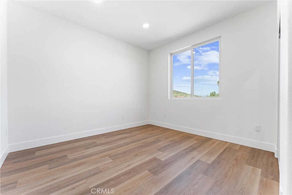 1981 Lyon Avenue Riverside, CA 92503 - Photo 16 of 58 an empty room with wooden floor and windows