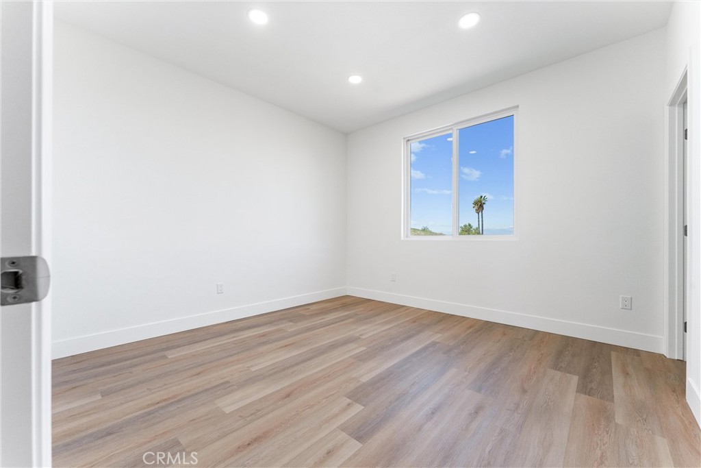 1981 Lyon Avenue Riverside, CA 92503 - Photo 31 of 58 an empty room with wooden floor and windows