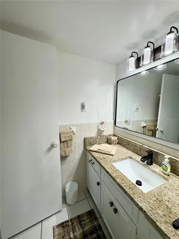 a bathroom with a granite countertop sink and a mirror