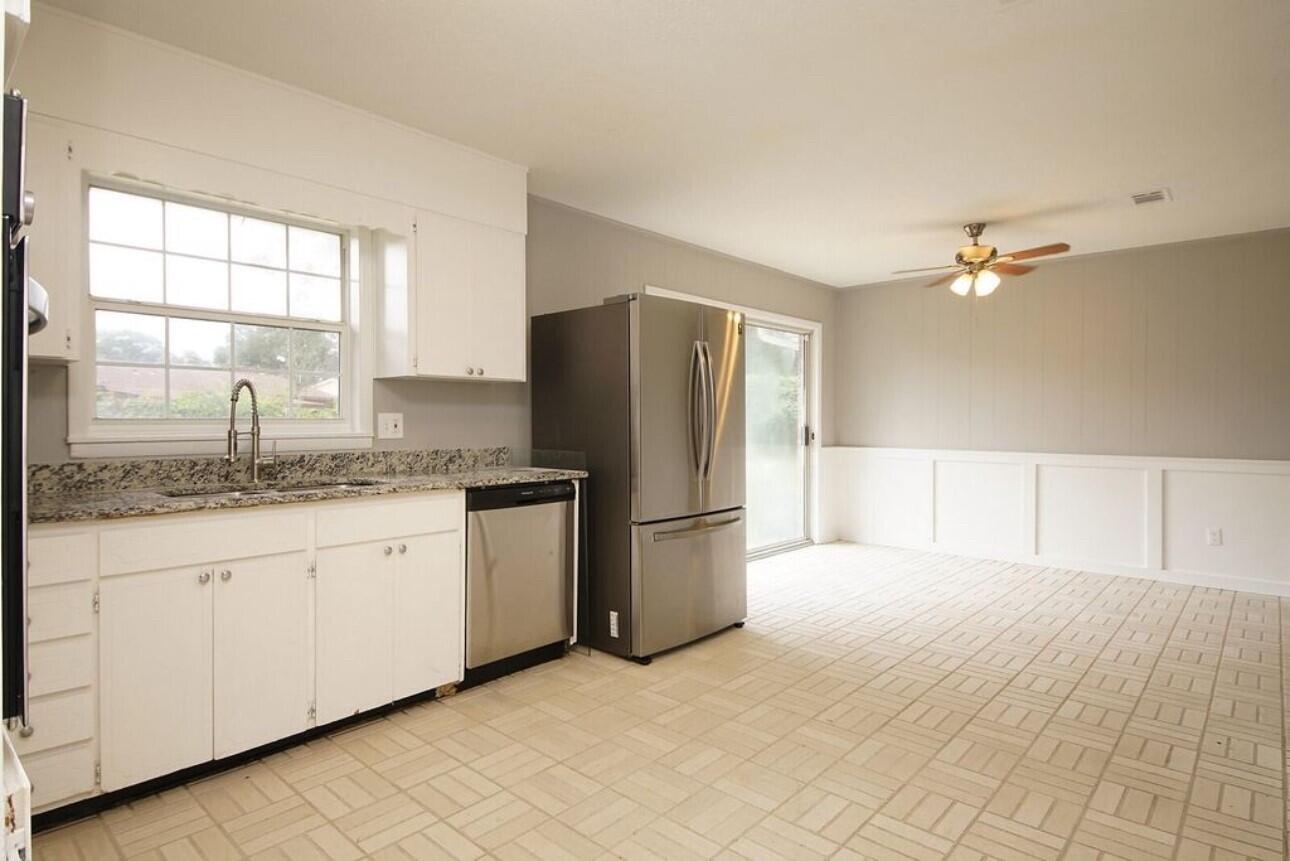 315 Sudduth Circle Northeast Fort Walton Beach, FL 32548 - Photo 13 of 30 a kitchen with granite countertop a sink cabinets stainless steel appliances and a window