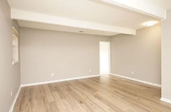 a view of an empty room with wooden floor