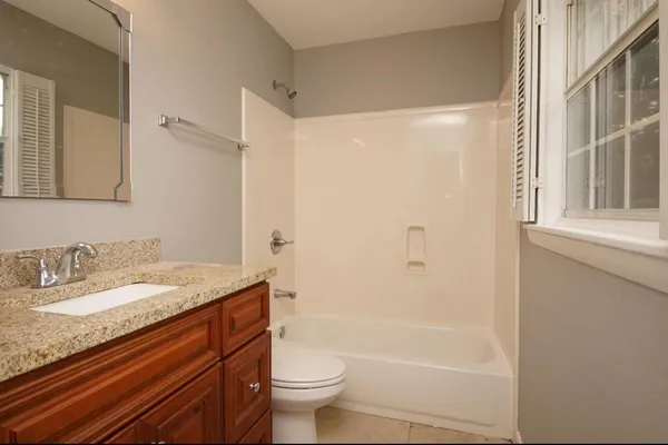 a bathroom with a granite countertop sink toilet and shower