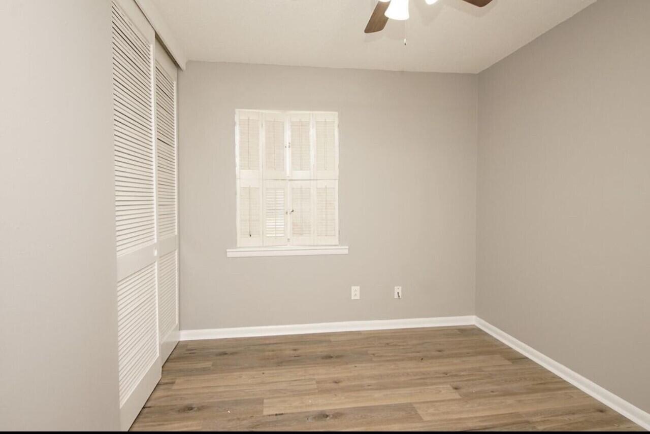 315 Sudduth Circle Northeast Fort Walton Beach, FL 32548 - Photo 5 of 30 an empty room with wooden floor cabinet and windows