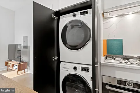 a utility room with dryer washer and a view of living room
