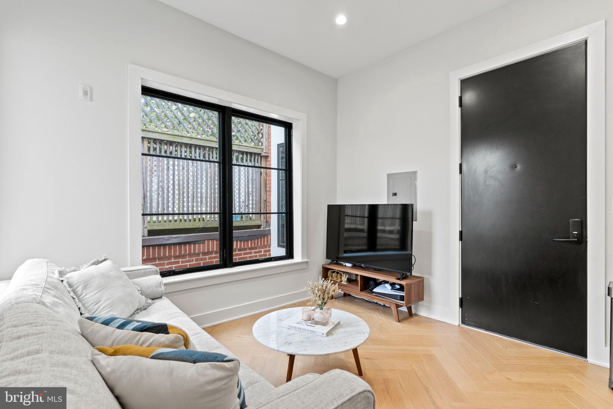 1225 11th Street Northwest, Unit 9 Washington, DC 20001 - Photo 6 of 20 a living room with furniture and a flat screen tv