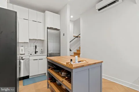 a kitchen with stainless steel appliances a sink cabinets and wooden floor