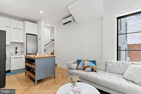 a living room with stainless steel appliances kitchen island granite countertop furniture a refrigerator a sink and a stove