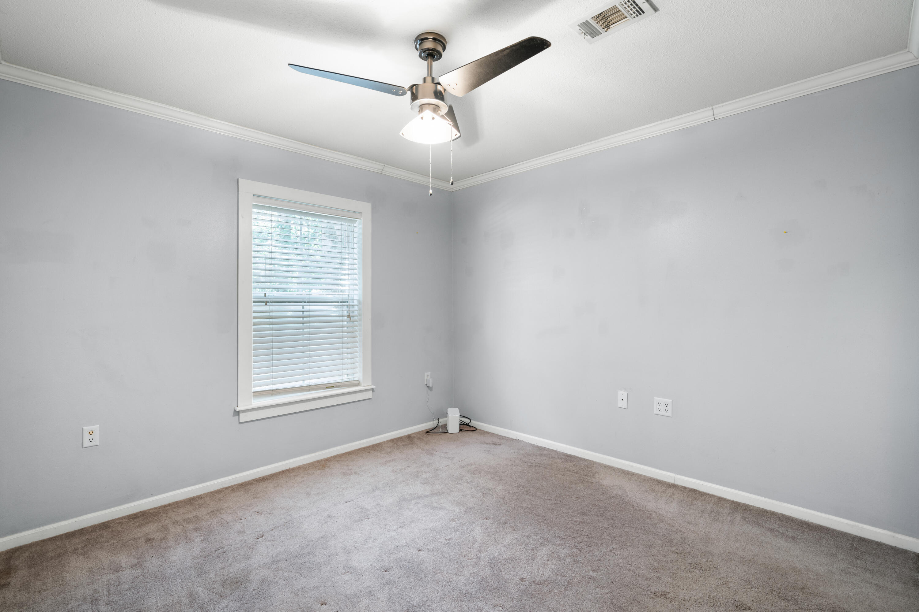 40 Horseshoe Lane Freeport, FL 32439 - Photo 12 of 16 an empty room with a chandelier fan and windows