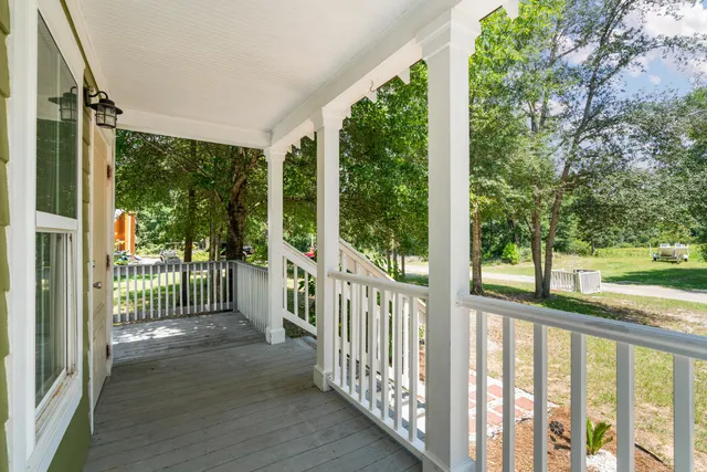a view of a porch with wooden floor and floor to ceiling window