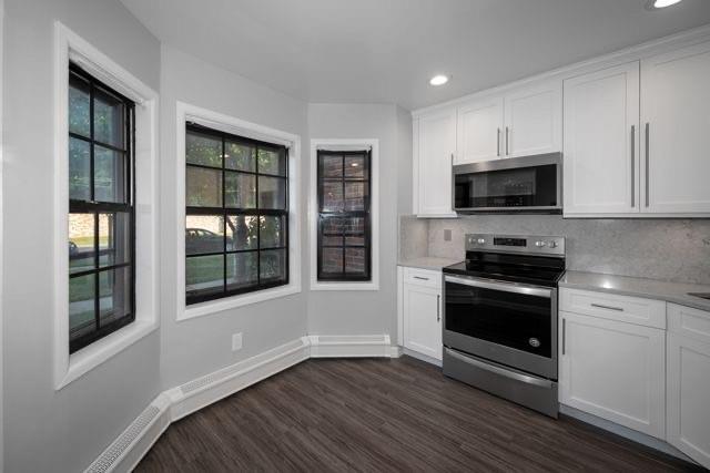 a kitchen with granite countertop a stove and a microwave