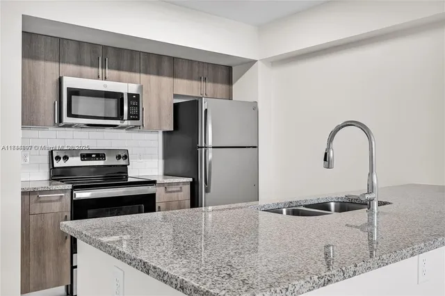 a kitchen with stainless steel appliances granite countertop a sink and a granite counter top
