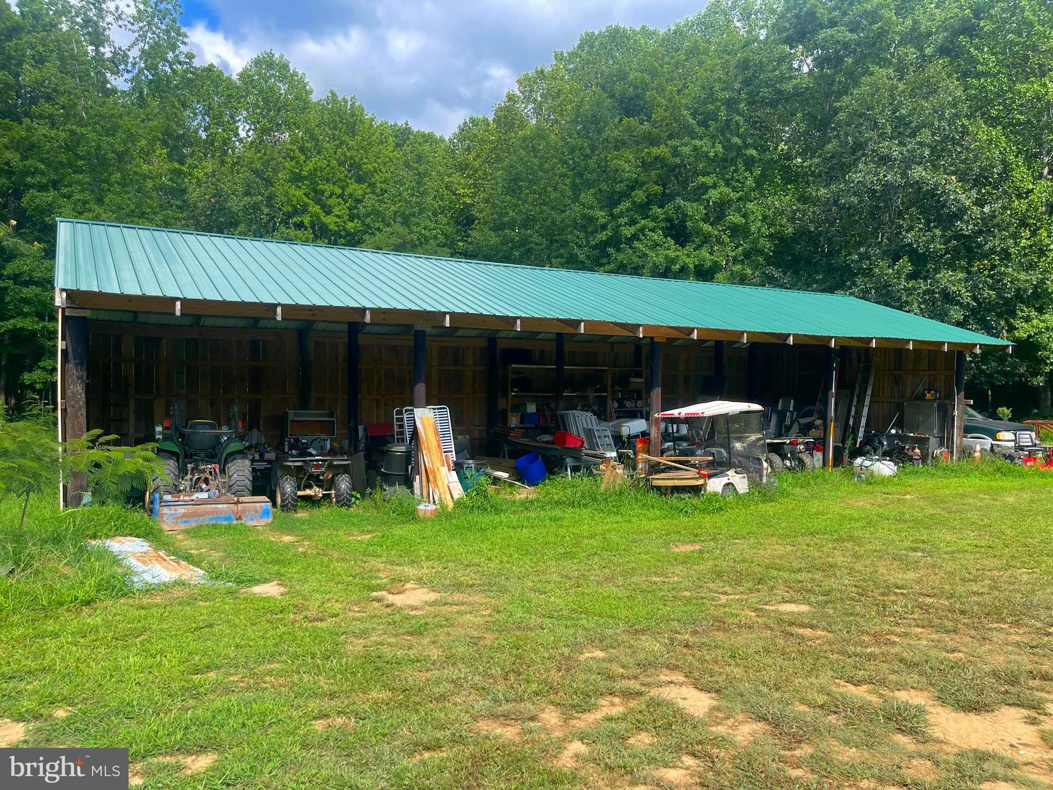 6310 St Leonard Road St. Leonard, MD 20685 - Photo 5 of 16 a view of a backyard with table and chairs under an umbrella with wooden fence