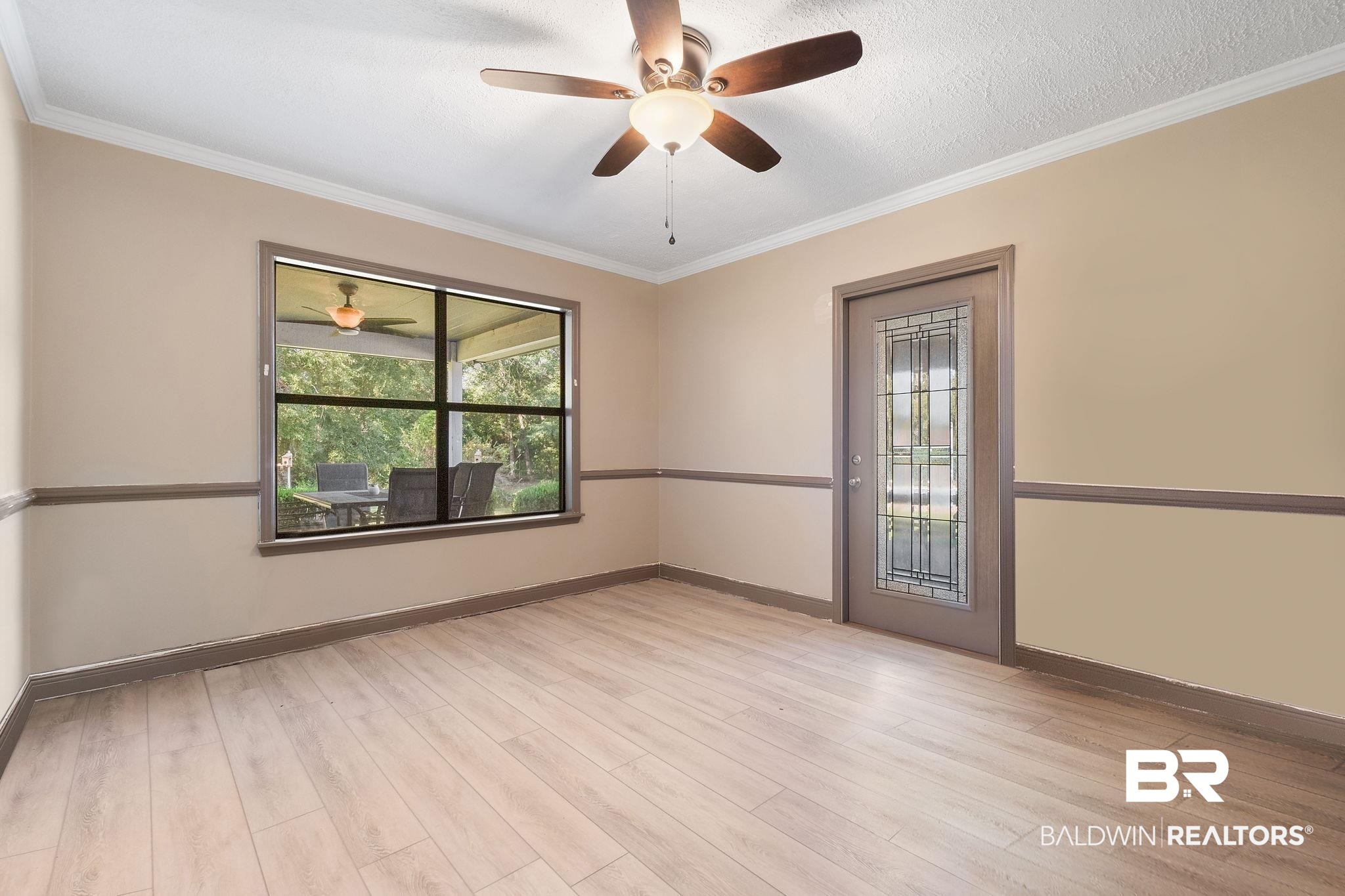 27300 C R Watson Road Robertsdale, AL 36567 - Photo 21 of 35 Unfurnished room featuring ceiling fan, ornamental molding, light wood-type flooring, and a textured ceiling