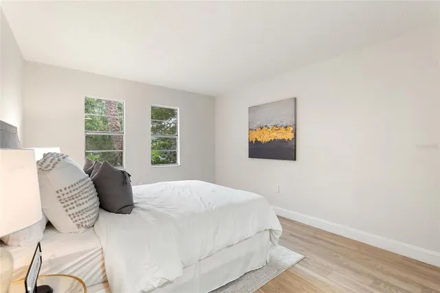 a bedroom with a bed and wooden floor