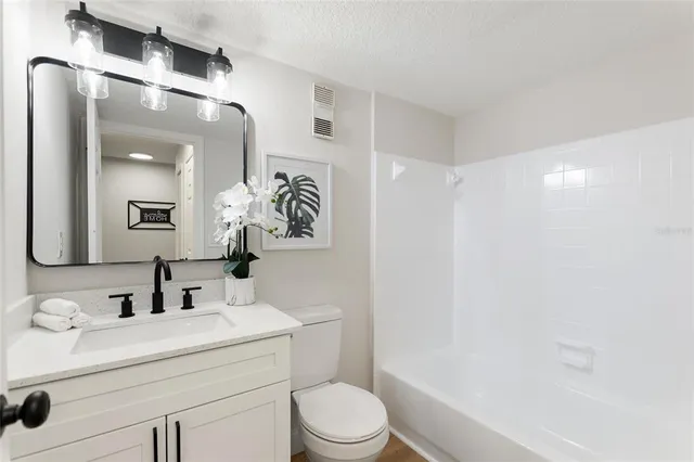 a bathroom with a sink toilet vanity and shower