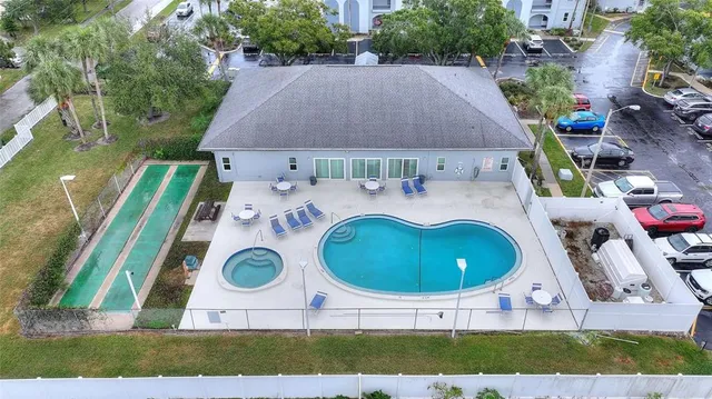 an aerial view of a house with backyard space and swimming pool