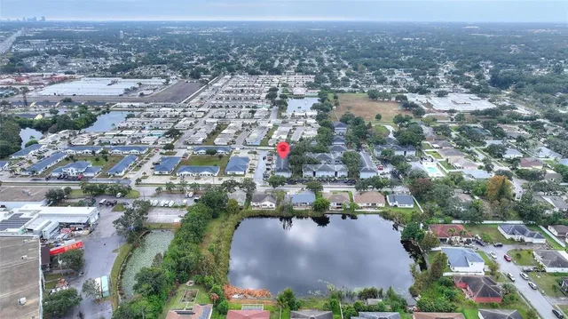 an aerial view of residential houses with outdoor space and trees