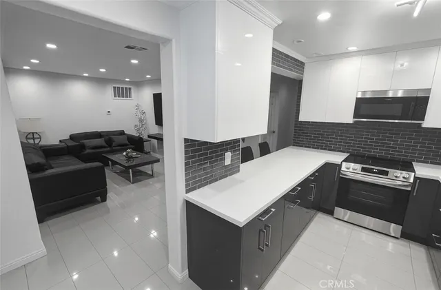 a kitchen with stainless steel appliances granite countertop a sink a stove a refrigerator and a microwave