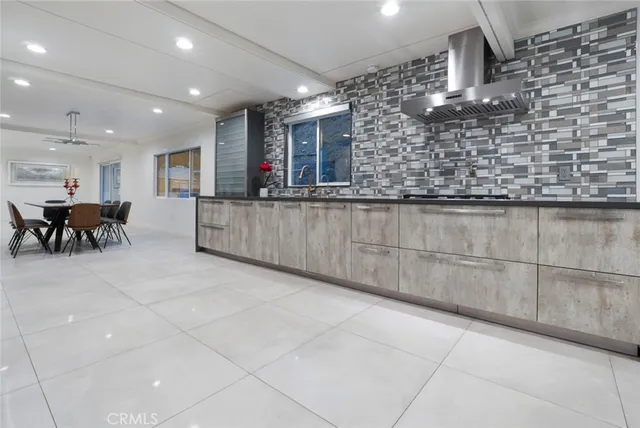 a living room with stainless steel appliances kitchen island granite countertop a sink and cabinets