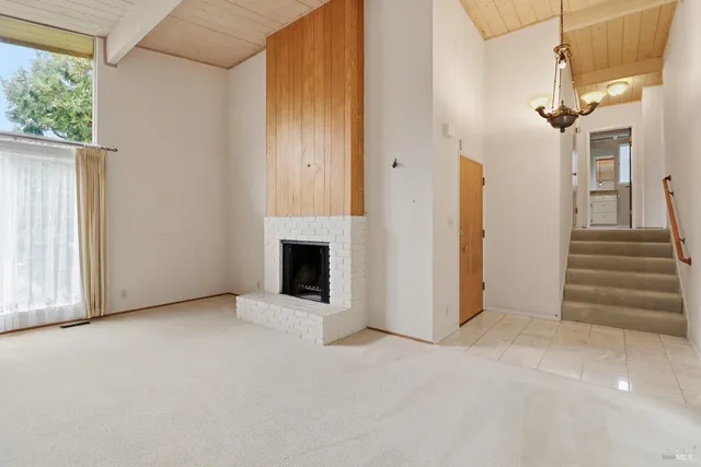 a view of a livingroom with an empty space and a fireplace