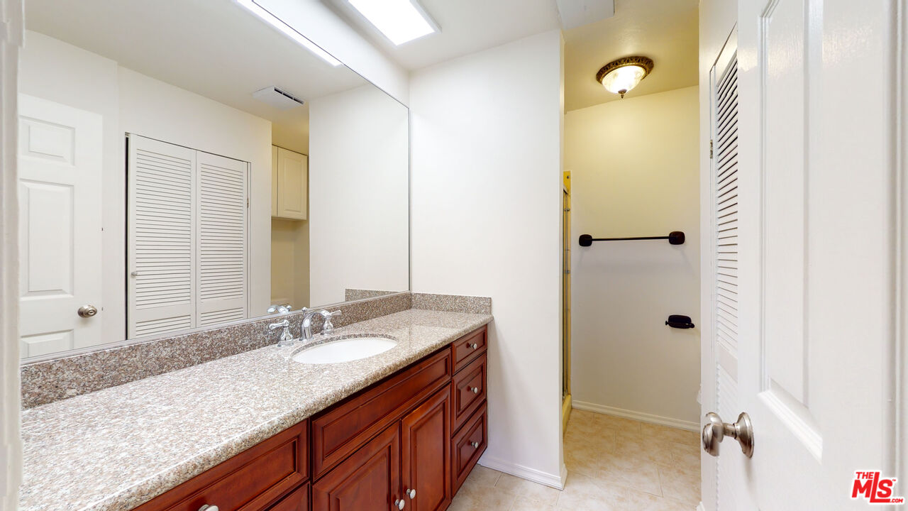8600 Tuscany Avenue, Unit 202 Playa del Rey, CA 90293 - Photo 11 of 29 a bathroom with a granite countertop sink and a mirror