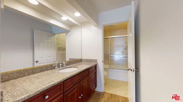 a bathroom with a granite countertop sink and a mirror
