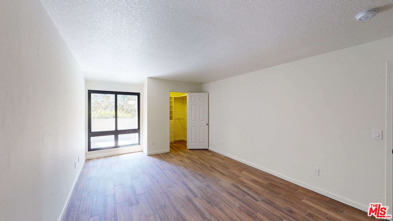 8600 Tuscany Avenue, Unit 202 Playa del Rey, CA 90293 - Photo 17 of 29 a view of an empty room with window and wooden floor