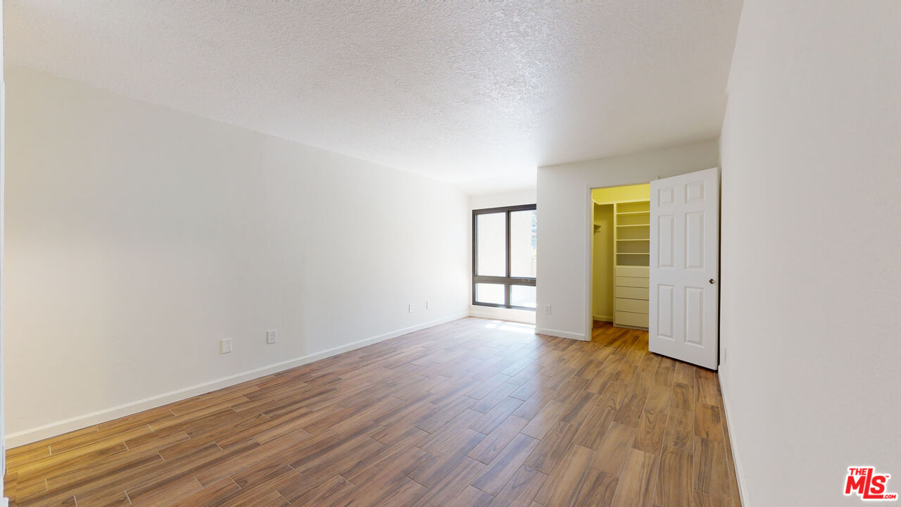 8600 Tuscany Avenue, Unit 202 Playa del Rey, CA 90293 - Photo 18 of 29 a view of an empty room with a window and wooden floor