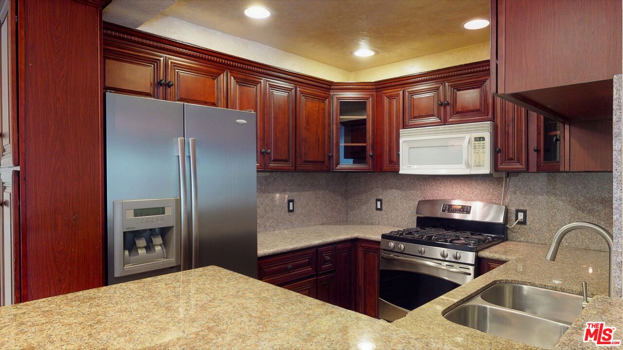 8600 Tuscany Avenue, Unit 202 Playa del Rey, CA 90293 - Photo 2 of 29 a kitchen with stainless steel appliances granite countertop a refrigerator and a sink