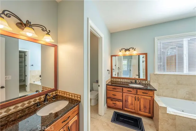 a bathroom with a granite countertop tub sink and mirror