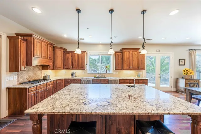a kitchen with stainless steel appliances granite countertop wooden cabinets sink and stove